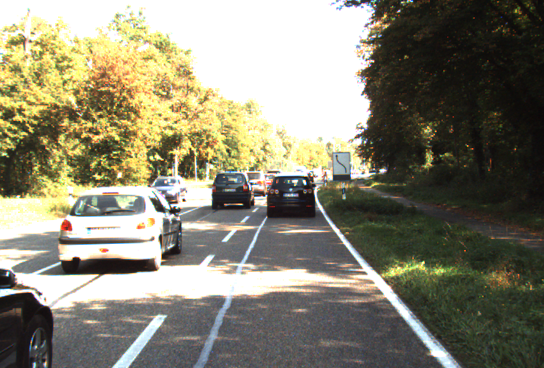 The filename-matched real tree-lined road with several cars.